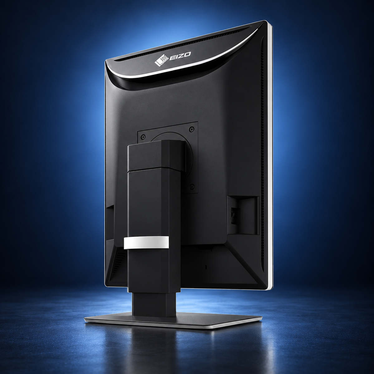EIZO RadiForce RX370 monitor, angled rear view showing the black housing and stand on a dark blue studio background.