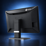 EIZO RadiForce MX243W monitor, angled rear view showing the black housing and stand on a dark blue studio background.